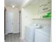 Bright laundry room featuring a white washer and dryer, light shelves, and neutral-colored walls and flooring at 2172 Palermo Pl, North Charleston, SC 29406