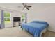 Spacious bedroom with neutral carpet, ceiling fan, and two windows with view to backyard at 251 Coosawatchie St, Summerville, SC 29485