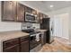Well-equipped kitchen with black appliances, dark wood cabinets, and stylish countertops at 251 Coosawatchie St, Summerville, SC 29485
