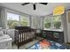 Well-lit bedroom with a crib, ceiling fan, world map rug and ample natural light at 2605 Mona Ave, Charleston, SC 29414