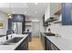 Open kitchen with stainless steel appliances, blue cabinets, and white countertops at 2605 Mona Ave, Charleston, SC 29414