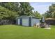 A blue shed in a well-maintained backyard, complemented by an outdoor dining set on a patio at 2605 Mona Ave, Charleston, SC 29414