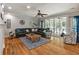 Spacious living room featuring a large sectional, wooden floors, ceiling fan and backyard views at 2649 Starfish Dr, Johns Island, SC 29455