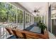 Spacious screened porch with a wooden swing, ceiling fans, rocking chairs, and views of the surrounding trees at 2649 Starfish Dr, Johns Island, SC 29455