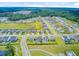 Aerial view of a residential community with pond, a field and factory in background at 266 Torslanda Ln, Summerville, SC 29486