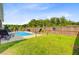 Landscaped backyard with private pool, patio furniture, and a wooden fence at 266 Torslanda Ln, Summerville, SC 29486