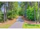 A paved walking path winds through a serene wooded area, inviting residents to enjoy nature at 266 Torslanda Ln, Summerville, SC 29486