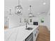 Bright, open kitchen featuring a large island, modern lighting, and a cozy fireplace in the adjacent living area at 2872 Edenborough Rd, Johns Island, SC 29455