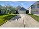 Picture of the front of a beige home with a two-car garage and a large driveway on a sunny day at 2910 John Cabot Dr, North Charleston, SC 29420