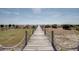 Wooden walkway with rope railings leading to the beach and ocean at 3004 Point St, Edisto Island, SC 29438