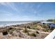 Beautiful beach view with sand dunes, ocean, and single Gathering home near the coast at 3004 Point St, Edisto Island, SC 29438
