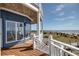 View of a wooden deck with white railings overlooking the beach and ocean at 3004 Point St, Edisto Island, SC 29438