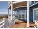 View of a wooden deck with white railings overlooking the beach and ocean at 3004 Point St, Edisto Island, SC 29438
