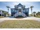 Attractive two-story beach house with blue siding, double staircases, and well-manicured lawn at 3004 Point St, Edisto Island, SC 29438