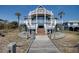 Stunning exterior view of a multi-story beach house with a wooden walkway at 3004 Point St, Edisto Island, SC 29438