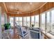 Bright sunroom with wood-paneled ceiling, walls, hardwood floors, and ocean views at 3004 Point St, Edisto Island, SC 29438