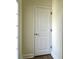 Hallway with white trim and baseboards leading to a door, offering a seamless transition between spaces at 3006 Central Ring Ct, Ridgeville, SC 29472