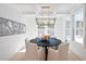 Stylish dining room featuring a modern chandelier, dark wood table, and bright natural light at 311 Papa Charlie Way, Charleston, SC 29412