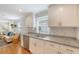 Bright kitchen featuring white cabinets, granite countertops, stainless steel dishwasher, and hardwood flooring at 4587 Durant Ave, North Charleston, SC 29405