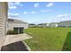 Expansive backyard featuring a lush lawn, patio area, and residential views under a bright, partly cloudy sky at 491 Cedarview Rd, Summerville, SC 29486