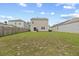 Large backyard enclosed by a wooden fence, with a view of the rear exterior of the house and neighboring homes at 491 Cedarview Rd, Summerville, SC 29486