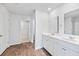This bright bathroom features a double vanity, vinyl floor, and an open door to the walk-in closet at 491 Cedarview Rd, Summerville, SC 29486