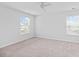 A spacious bedroom features neutral carpet, a ceiling fan, two windows, and light gray walls at 491 Cedarview Rd, Summerville, SC 29486