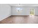 Bright living room with wood-look floors, a ceiling fan, a large window, and sliding glass doors leading to the exterior at 491 Cedarview Rd, Summerville, SC 29486