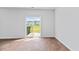 Bright living room with wood-look floors and sliding glass doors leading to the exterior and trash containers at 491 Cedarview Rd, Summerville, SC 29486
