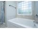 Bathroom showcasing a luxurious soaking tub with a glass block window at 5023 Manor Rd, Hollywood, SC 29449