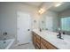 Bathroom with double sink vanity, large mirror, and a soaking tub at 5023 Manor Rd, Hollywood, SC 29449