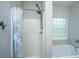 Bright bathroom featuring shower, soaking tub, and natural light from a glass block window at 5023 Manor Rd, Hollywood, SC 29449