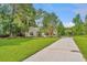 Cozy one-story home with a long driveway leading to a basketball court at 5023 Manor Rd, Hollywood, SC 29449
