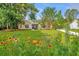 Charming single-Gathering home with a beautiful front yard featuring colorful flowers and mature trees at 5023 Manor Rd, Hollywood, SC 29449