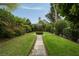 Serene backyard garden with a stone path, mature trees, and meticulously maintained landscaping at 55 E Bay St, Charleston, SC 29401