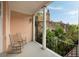 Inviting balcony features rocking chairs and a serene view of lush greenery and historic architecture at 55 E Bay St, Charleston, SC 29401