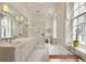 Spa bathroom with double sinks, glass shower, and soaking tub, creating a serene space at 55 E Bay St, Charleston, SC 29401