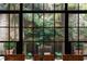 Framed view of a lush courtyard from a window featuring mature landscaping and a brick wall at 55 E Bay St, Charleston, SC 29401