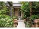 Inviting front porch with chairs, lush greenery, and beautiful brickwork, creating a cozy outdoor space at 55 E Bay St, Charleston, SC 29401