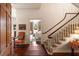 Hallway with stairway featuring a curved banister, hardwood floors, and a glimpse into the living room at 55 E Bay St, Charleston, SC 29401