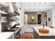 This spacious kitchen features open shelving, a stainless range hood, and an island with a farmhouse style sink at 55 E Bay St, Charleston, SC 29401
