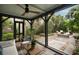 Screened porch with ceiling fan offers outdoor seating, and a view of the landscaped yard at 55 E Bay St, Charleston, SC 29401