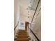 Staircase with runner, white railings and wood handrail leads to a wood door below an overhead light fixture at 55 E Bay St, Charleston, SC 29401