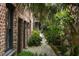 Charming walkway with lush landscaping, brick walls and iron gate at 55 E Bay St, Charleston, SC 29401