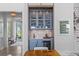 Stylish bar area with custom cabinetry, a wine cooler, and elegant lighting at 553 Old Compass Rd, Daniel Island, SC 29492