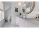 Elegant bathroom with patterned tile floors, a pink vanity, and a round mirror at 553 Old Compass Rd, Daniel Island, SC 29492