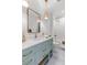 Charming bathroom with a mint vanity, gold fixtures, and a combination tub and shower at 553 Old Compass Rd, Daniel Island, SC 29492