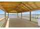 Wooden covered deck overlooking water with a railing, offering serene waterfront views at 553 Old Compass Rd, Daniel Island, SC 29492