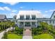 Stunning two-story home with metal roof, inviting front porch, meticulous landscaping, and vibrant green lawn at 553 Old Compass Rd, Daniel Island, SC 29492