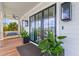 Cozy front porch with a swing seat, black framed windows, and manicured plants creating a welcoming entrance at 553 Old Compass Rd, Daniel Island, SC 29492